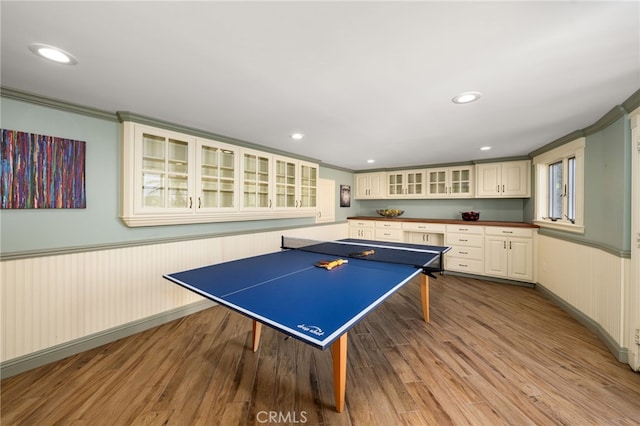 game room featuring a wainscoted wall, crown molding, wood finished floors, and recessed lighting