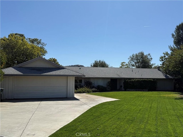 ranch-style house featuring a garage, concrete driveway, board and batten siding, and a front yard