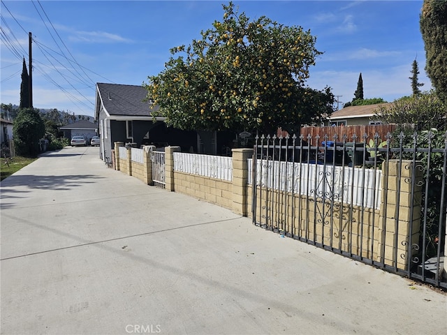 exterior space with driveway, a fenced front yard, and a gate