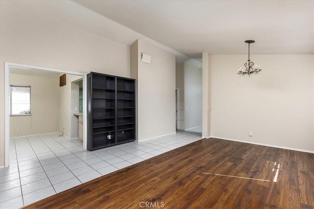 40292 Corte Delfin, Murrieta, CA 92562 - unfurnished room featuring an inviting chandelier, wood finished floors, baseboards, and lofted ceiling