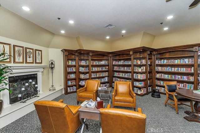 40292 Corte Delfin, Murrieta, CA 92562 - sitting room featuring visible vents, wall of books, a fireplace with raised hearth, and carpet flooring