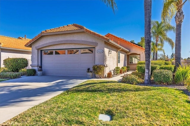 view of front of house featuring a garage, driveway, stucco siding, a tile roof, and a front yard