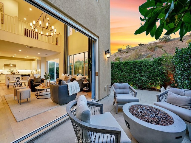 view of patio featuring an outdoor living space with a fire pit and a balcony