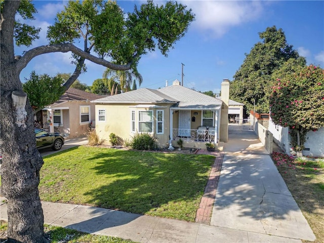 view of front of house featuring stucco siding, covered porch, a front lawn, and fence