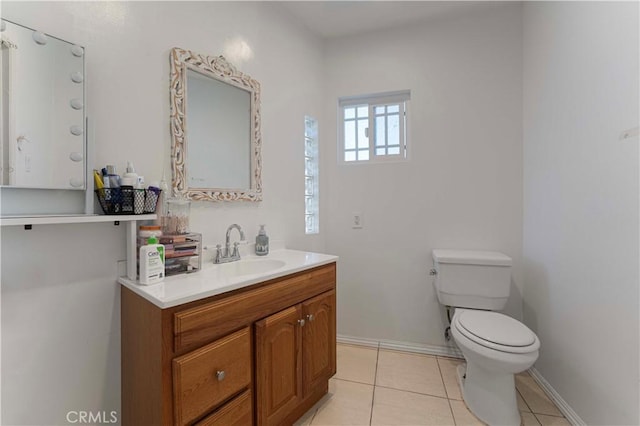 bathroom featuring tile patterned floors, toilet, vanity, and baseboards