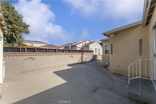 view of patio / terrace with fence and a residential view