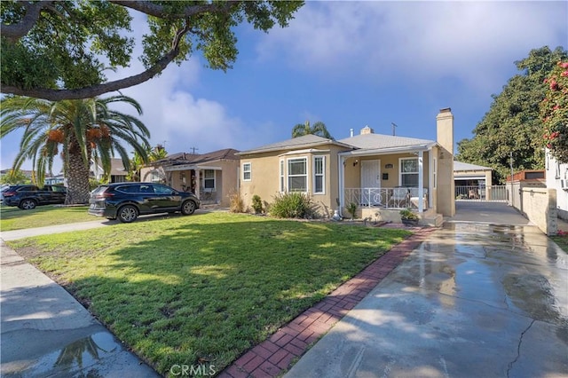 view of front of property featuring stucco siding, driveway, a porch, and a front yard