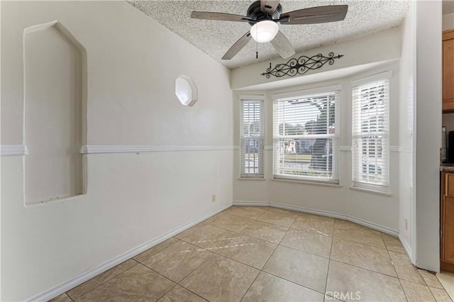 unfurnished room featuring light tile patterned floors, baseboards, and a textured ceiling