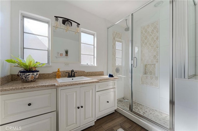 bathroom with a shower stall, wood finished floors, and vanity