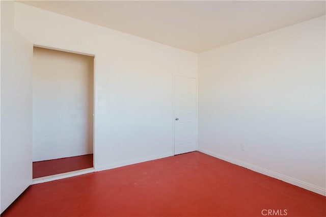 empty room featuring finished concrete floors and baseboards