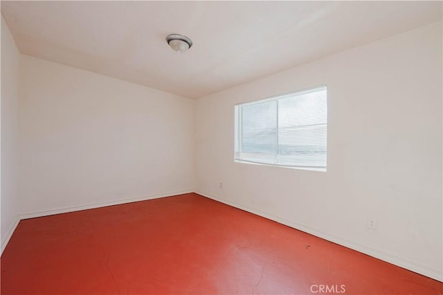 unfurnished room featuring baseboards and finished concrete floors