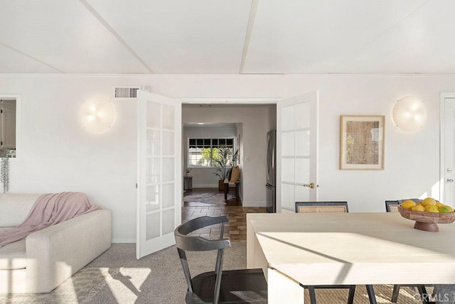 dining space with carpet floors, french doors, visible vents, and baseboards