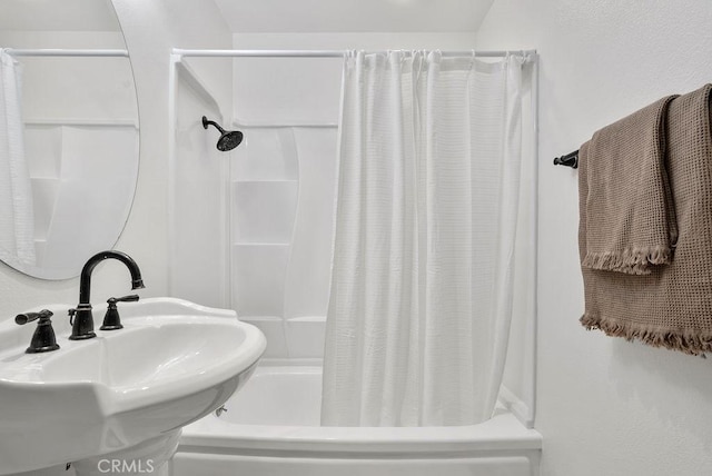 full bath featuring shower / tub combo with curtain and a sink