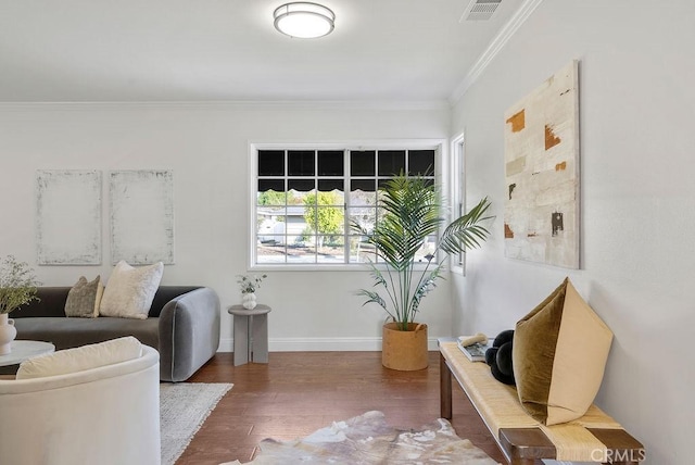 living area featuring baseboards, dark wood-style flooring, visible vents, and crown molding