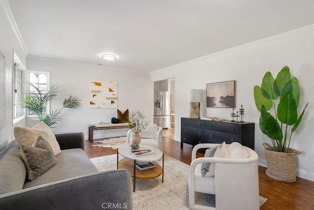 living room featuring crown molding, baseboards, and wood finished floors