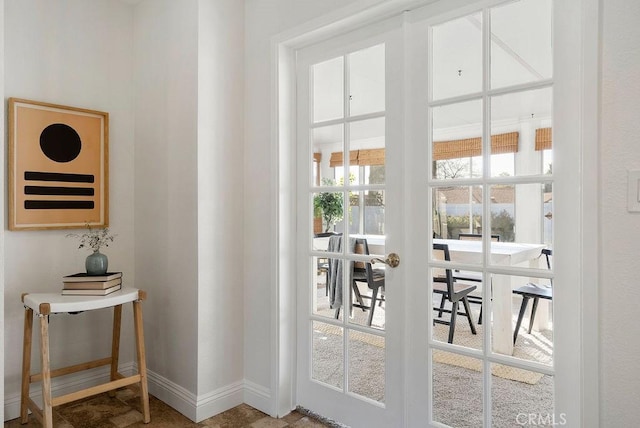 doorway to outside featuring french doors and baseboards