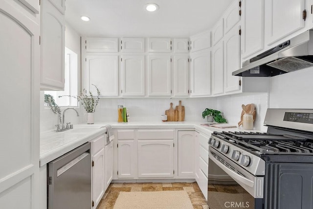 kitchen featuring under cabinet range hood, white cabinetry, stainless steel appliances, and light countertops