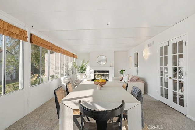 sunroom with a fireplace, visible vents, and french doors