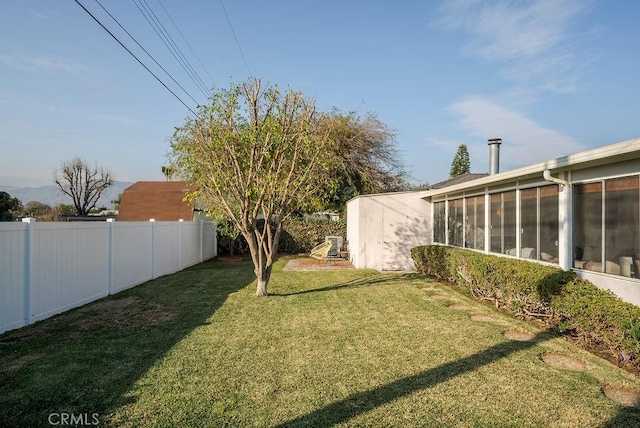 view of yard featuring a sunroom and a fenced backyard