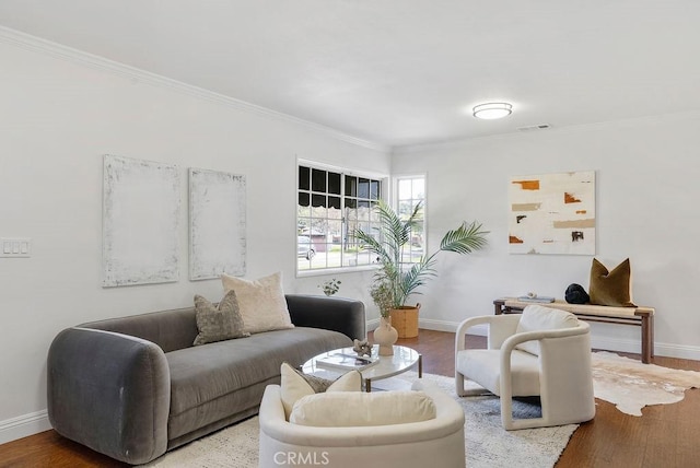 living room featuring ornamental molding, visible vents, baseboards, and wood finished floors