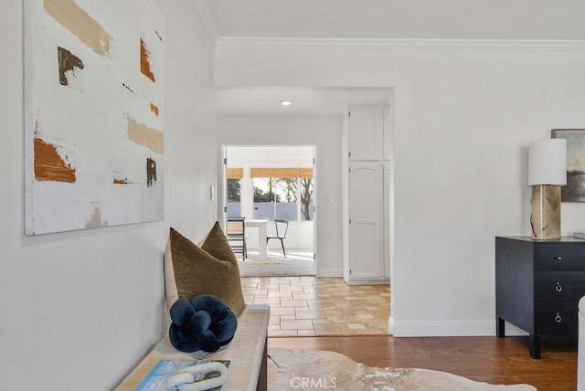 hallway with ornamental molding, baseboards, and wood finished floors