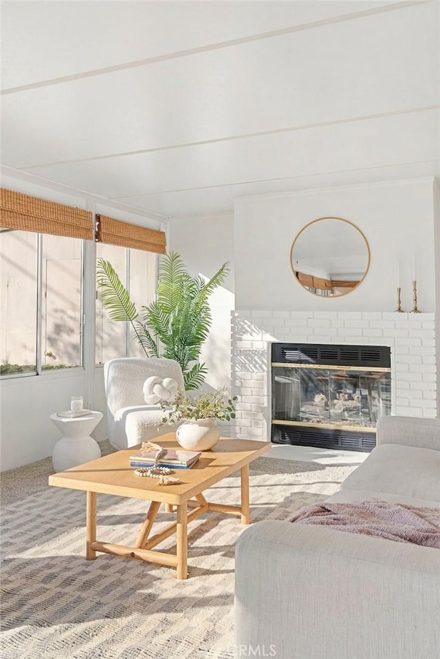 carpeted living area with a brick fireplace