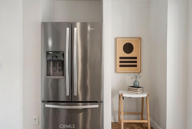 details with baseboards and stainless steel refrigerator with ice dispenser