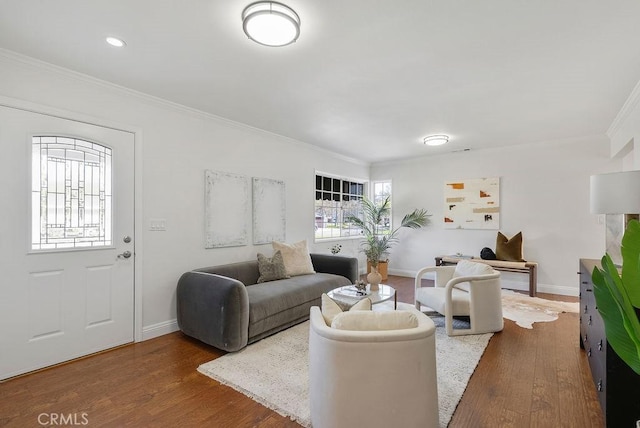 living area featuring baseboards, ornamental molding, and wood finished floors