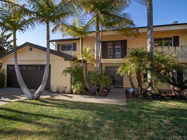 view of front of house with stucco siding, driveway, a front lawn, an attached garage, and a balcony