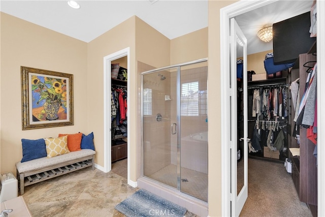 full bath featuring a shower stall, a spacious closet, and french doors