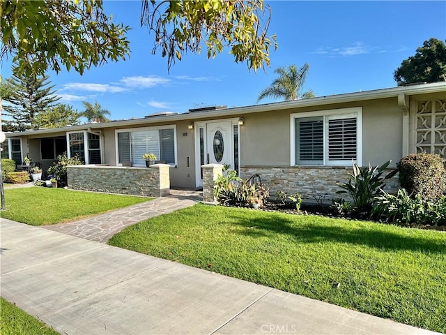 single story home with stone siding, a front yard, and stucco siding