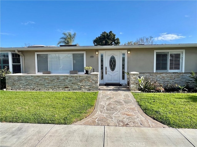 single story home featuring stone siding, a front lawn, and stucco siding