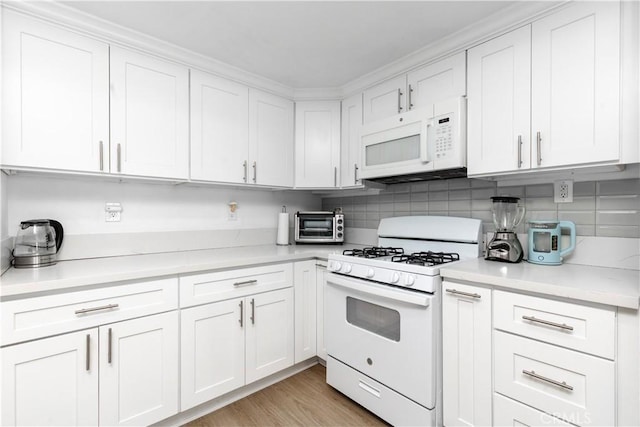 kitchen featuring light countertops, white cabinetry, and white appliances