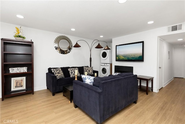 living room featuring visible vents, stacked washer and dryer, light wood-style floors, and recessed lighting