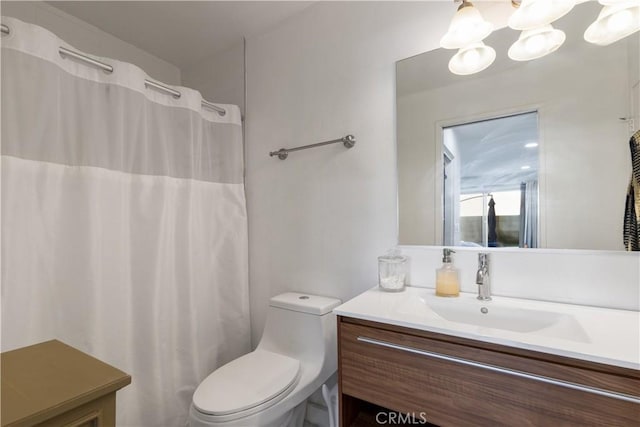 full bathroom featuring toilet, an inviting chandelier, curtained shower, and vanity