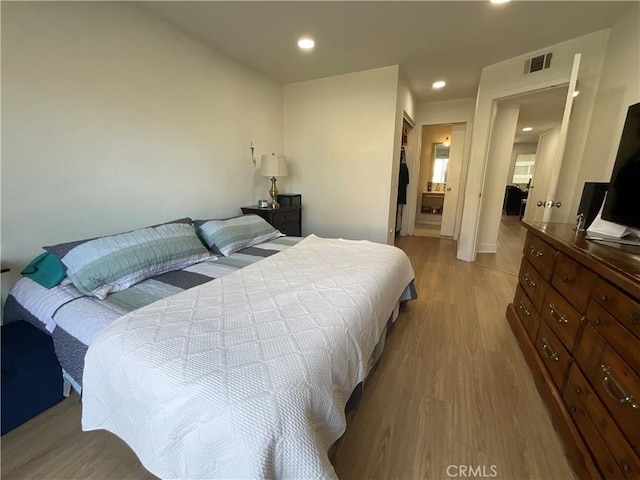 bedroom with light wood-style floors, a closet, recessed lighting, and visible vents