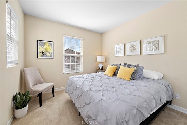 bedroom with baseboards and light colored carpet