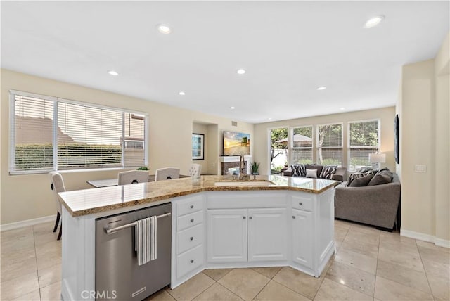 kitchen featuring a kitchen island, white cabinetry, open floor plan, and stainless steel dishwasher