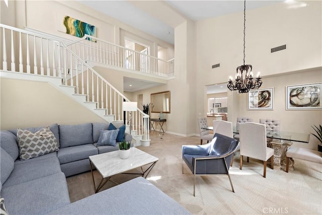 carpeted living room featuring an inviting chandelier, baseboards, stairs, and visible vents