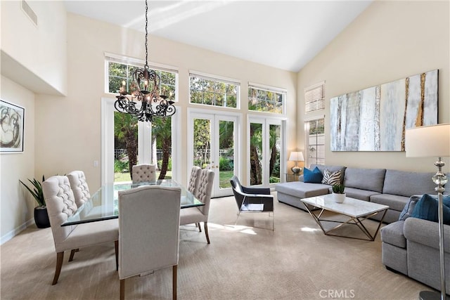 sunroom featuring a chandelier, french doors, and vaulted ceiling