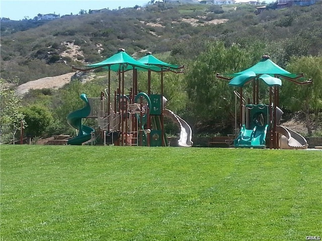 community play area with a mountain view and a lawn