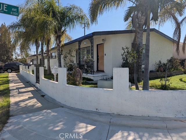 view of front of home with a fenced front yard and stucco siding