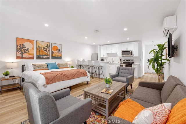 bedroom featuring light wood-type flooring, stainless steel fridge, an AC wall unit, and recessed lighting