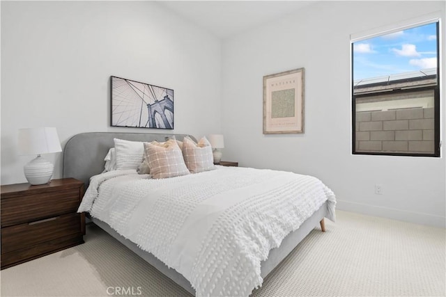 bedroom featuring light carpet and baseboards