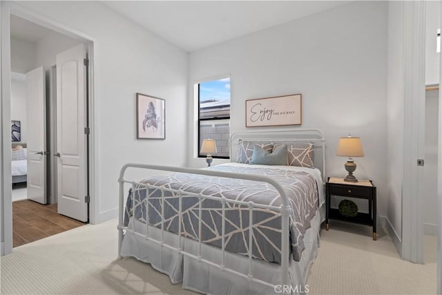 bedroom with light carpet and baseboards