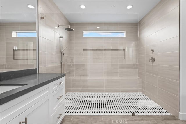 bathroom featuring a tile shower, vanity, and recessed lighting