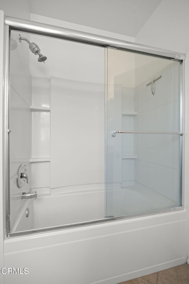 full bathroom featuring combined bath / shower with glass door and tile patterned flooring