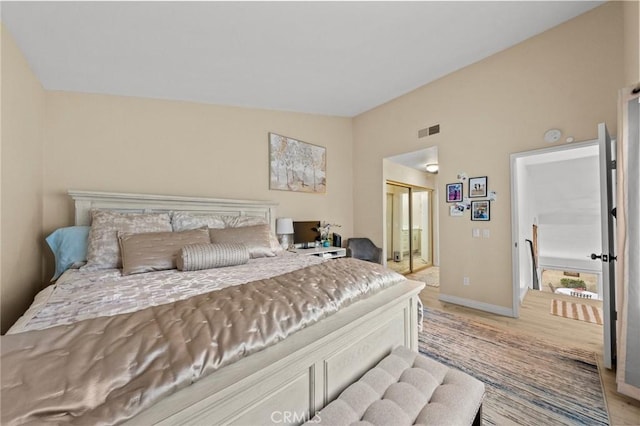 bedroom with lofted ceiling, light wood-style flooring, a closet, and visible vents