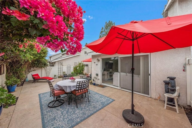 view of patio with outdoor dining space and fence