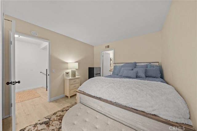 bedroom featuring light wood-style floors, baseboards, and visible vents